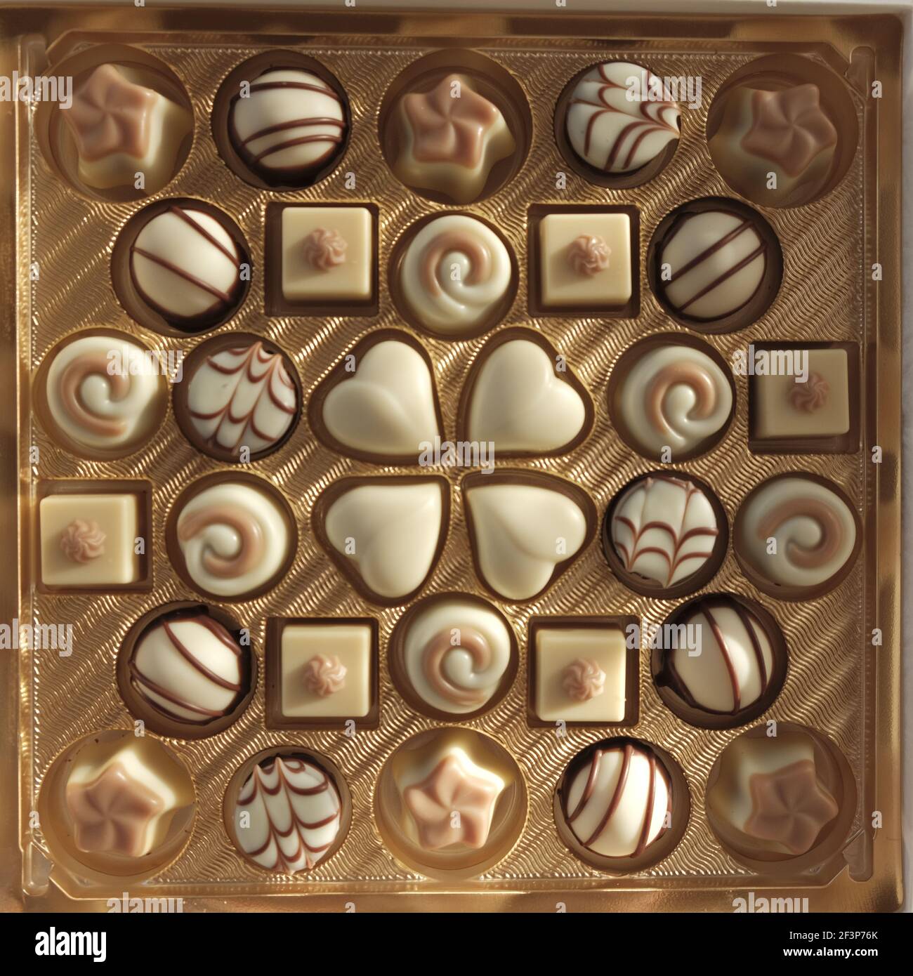 Chocolate candy .White chocolate. Assorted chocolate truffles in a gold