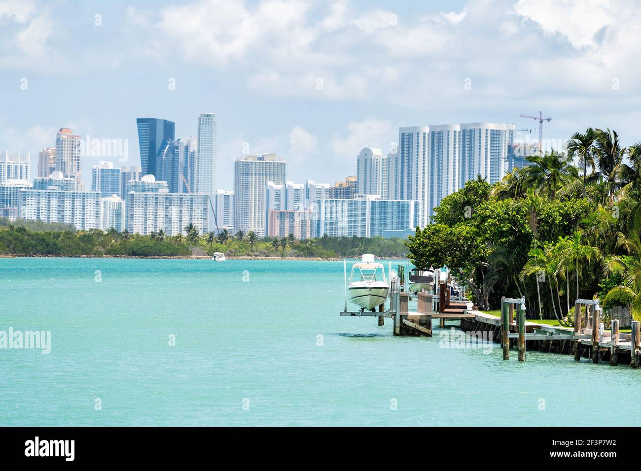 Bal Harbour, Miami Florida house dock with boat by light green turquoise ocean Biscayne Bay Intracoastal water and cityscape Sunny Isles Beach citysca Stock Photo