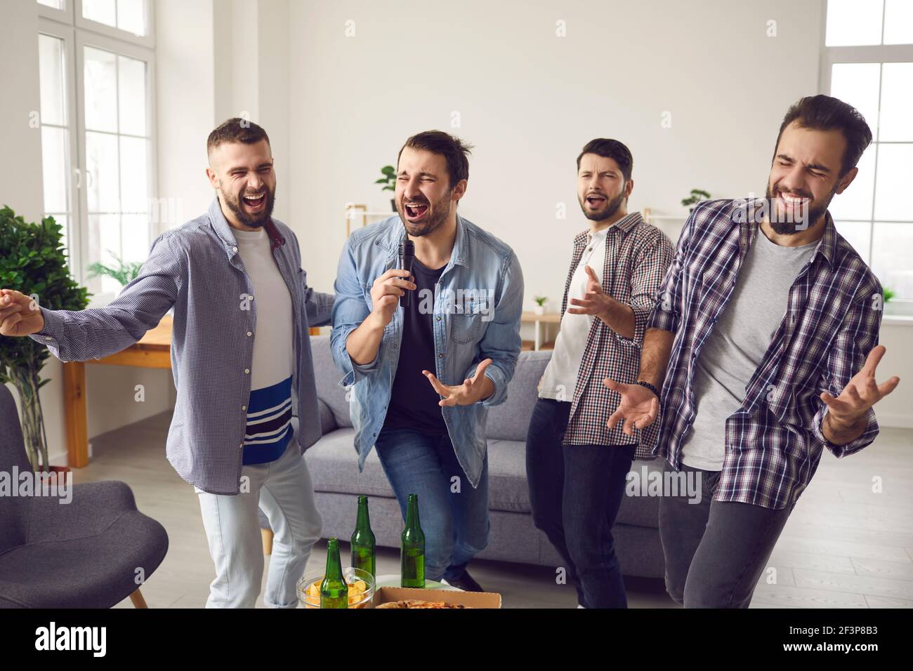 Karaoke home party and having fun for male company concept Stock Photo