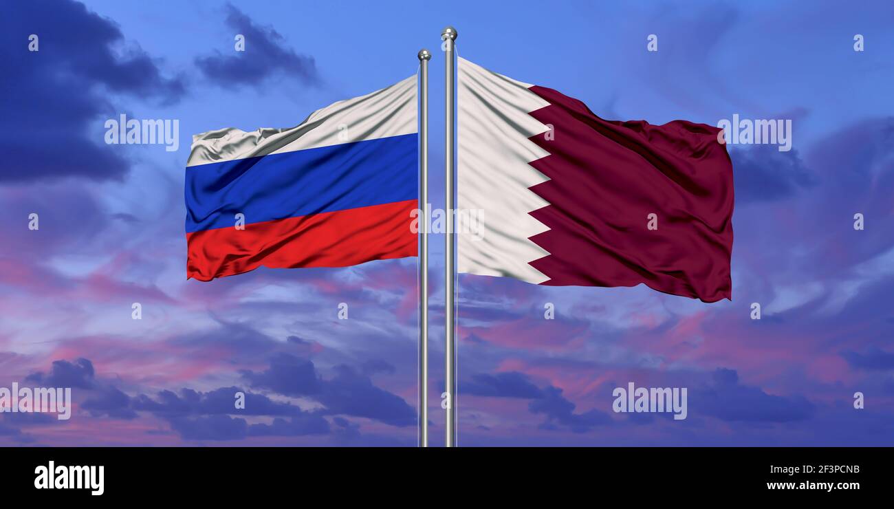 Qatar and Russia two flags on flagpoles and blue cloudy sky Stock Photo