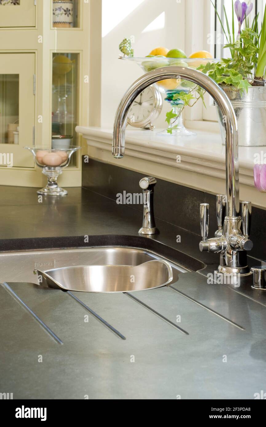 Traditional style mixer tap fitting over kitchen sink Stock Photo