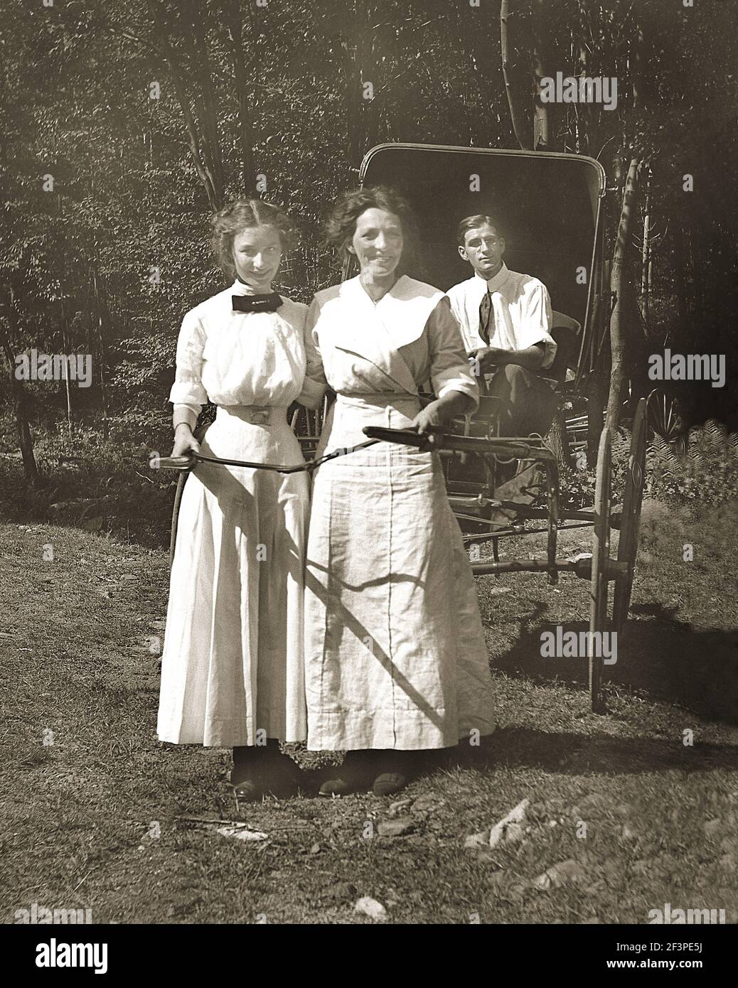 Two unidentified women pull a horse buggy with a man in it. from the early 1900's, Located at Bear Creek, Pennsylvania, USA. Stock Photo