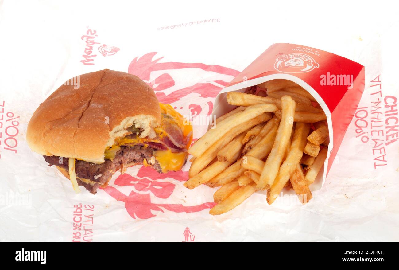 Open Wendy's Bacon Double Stack Cheeseburger with Bite taken & French Fries aka Chips on Wrapper Stock Photo