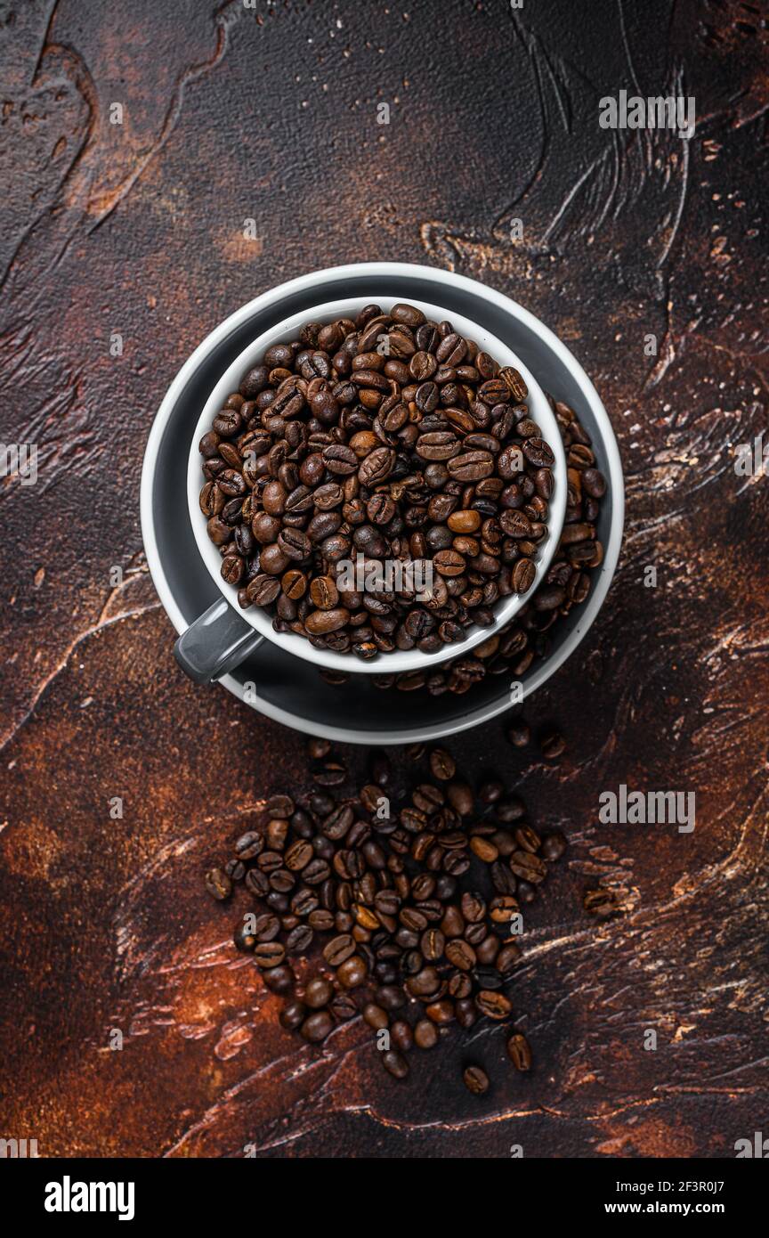 Dark roasted Coffee beans in a cup. Dark background. Top view Stock ...