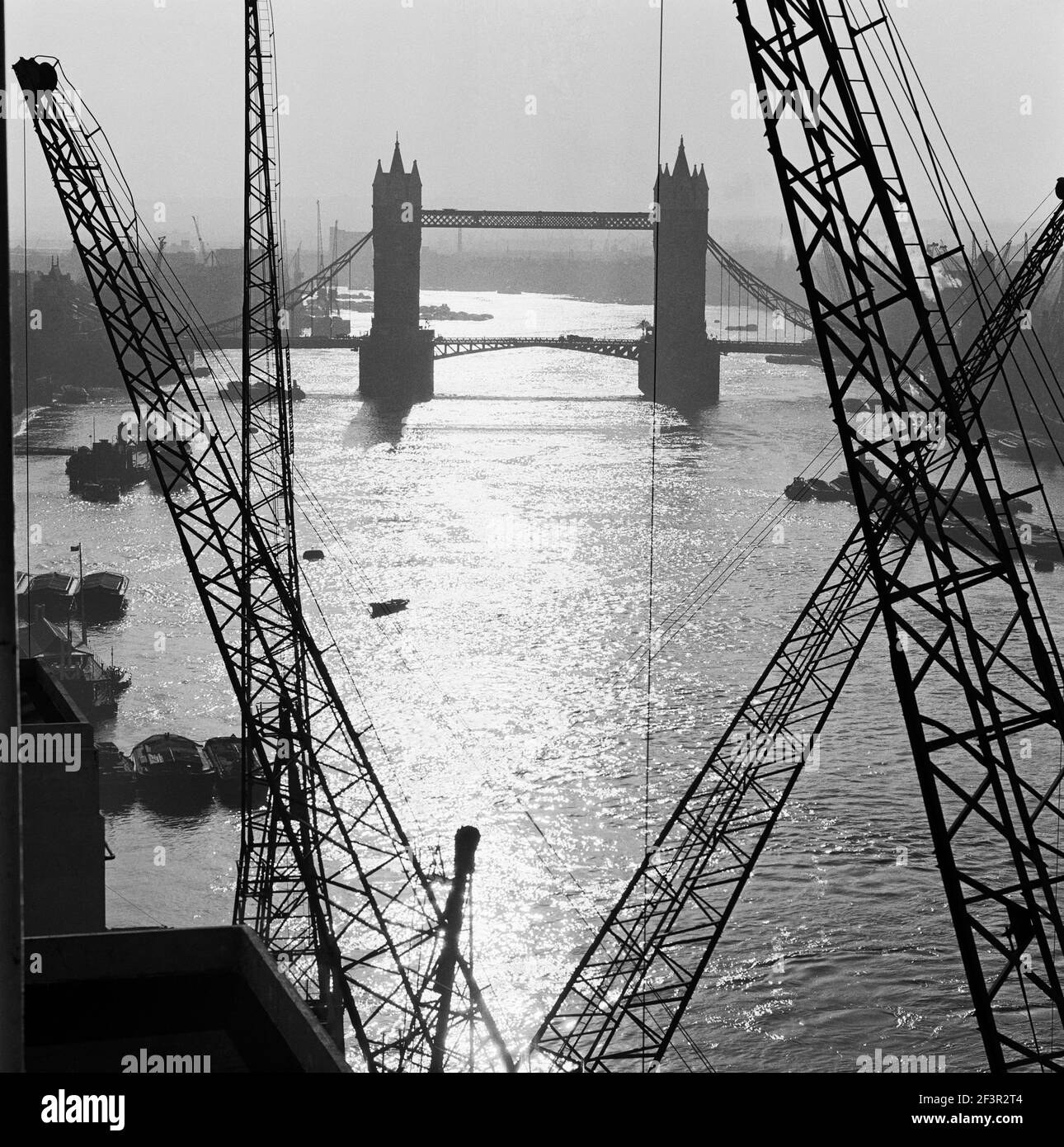 TOWER BRIDGE, London. The bridge seen from riverside gantries, looking east. The Thames is still a major port, with Thames barges and other vessels mo Stock Photo