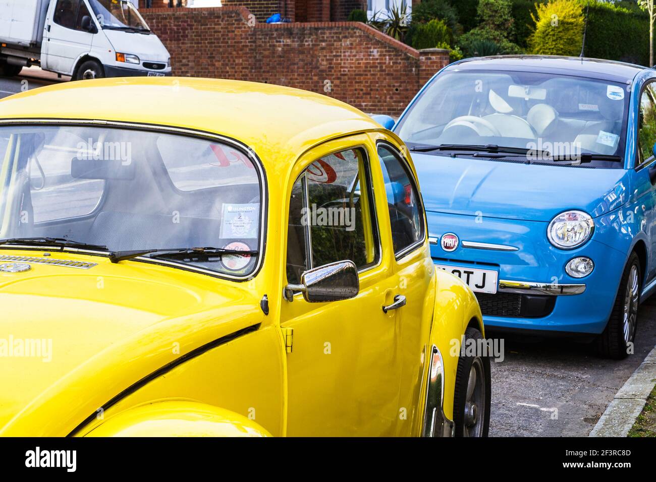 Bright yellow and blue cars parked in a residential area of North London, UK Stock Photo