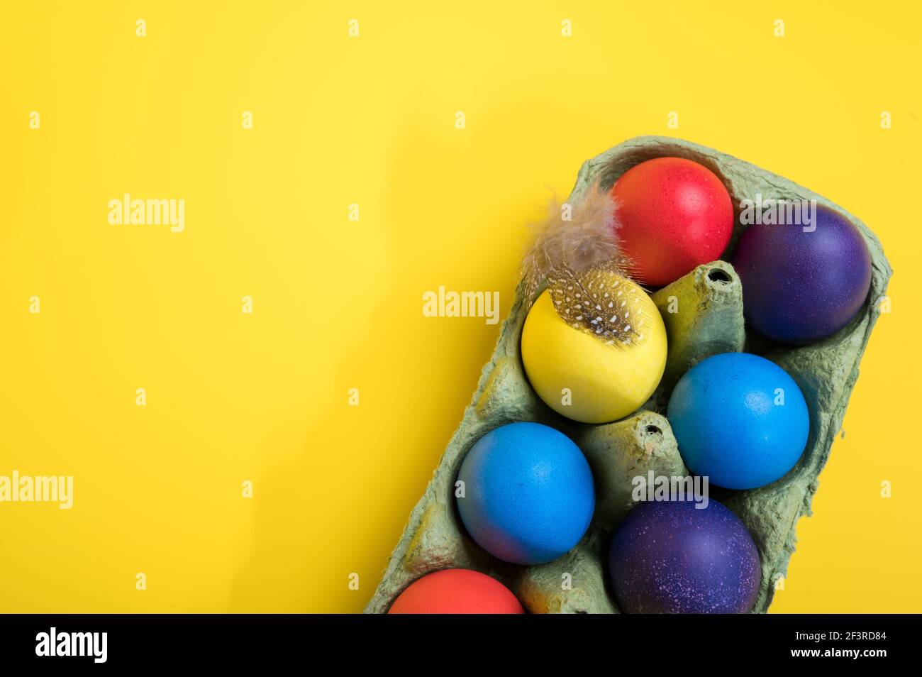 Multi-colored Easter eggs in an egg tray. Minimal concept. Card with copy space for text Stock Photo