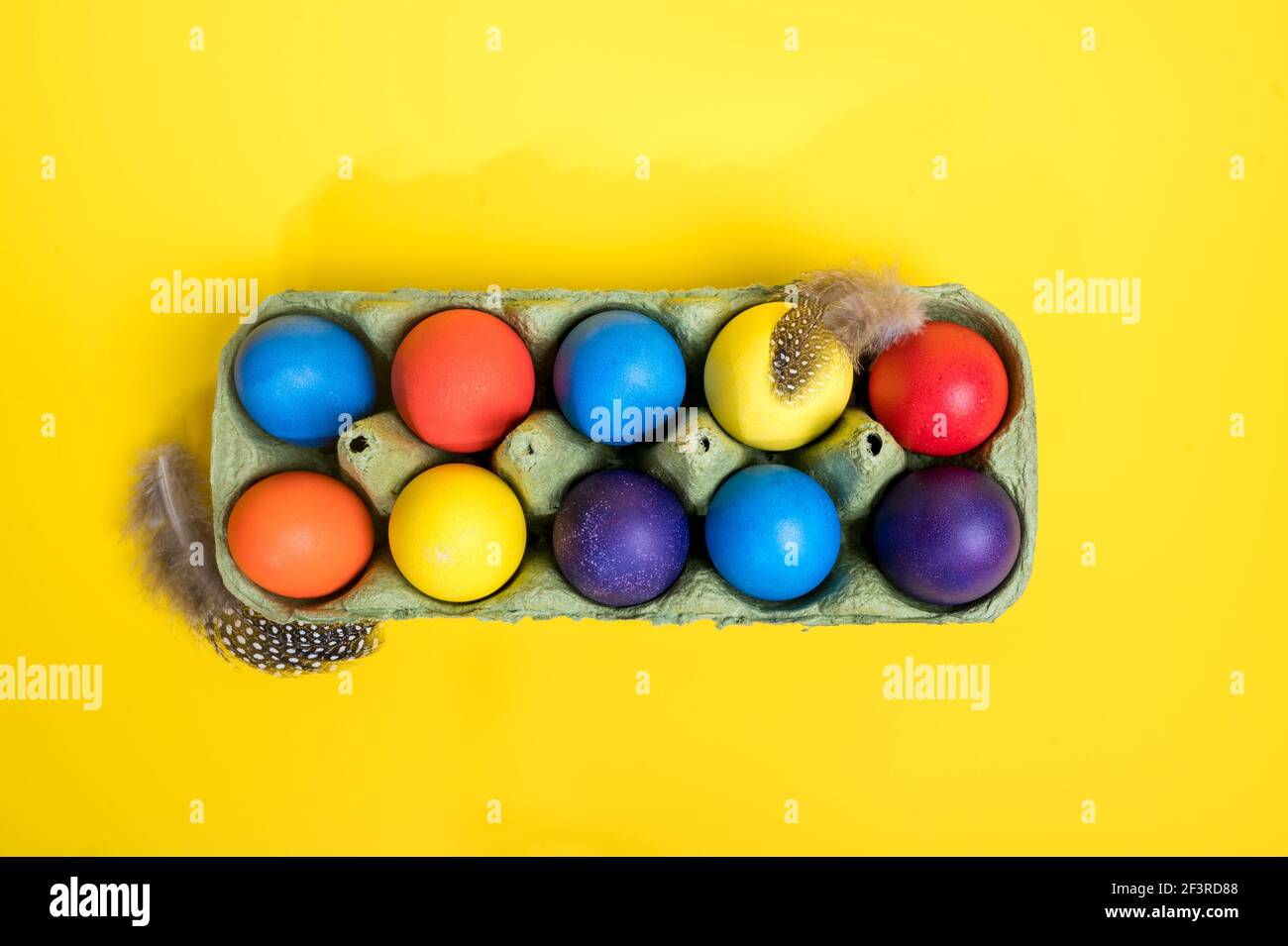 Multi-colored Easter eggs in an egg tray. Minimal concept. Card with copy space for text Stock Photo