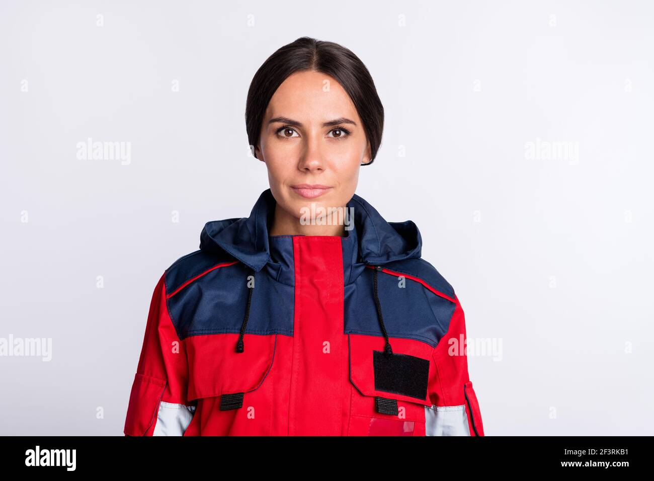 Photo of cute serious young lady paramedic dressed red uniform isolated