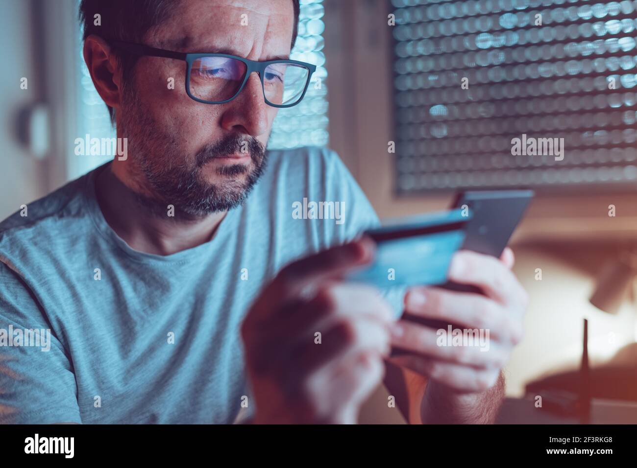 Online shopping security concern, man buying over internet with mobile smart phone and credit card, close up with selective focus Stock Photo