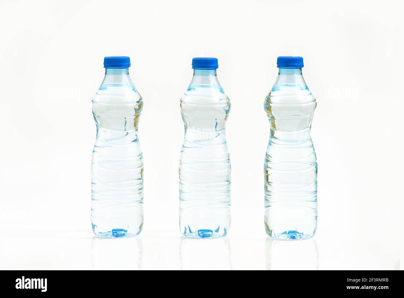 Bottled water isolated over a white background - three plastic bottles ...