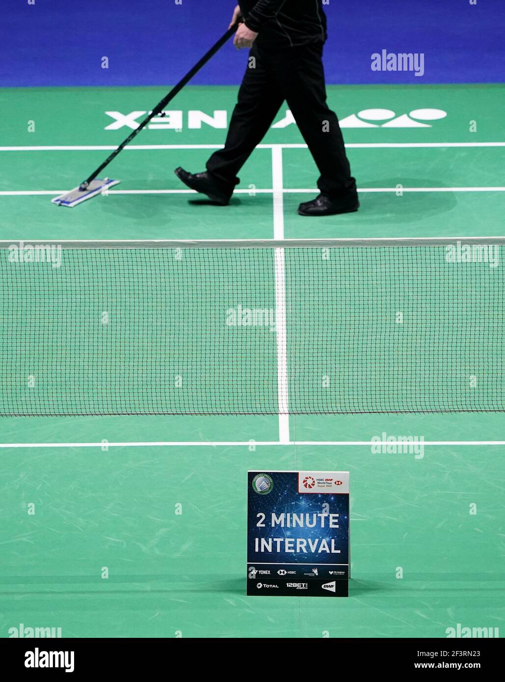 A referee cleans the court during an interval on day one of the YONEX
