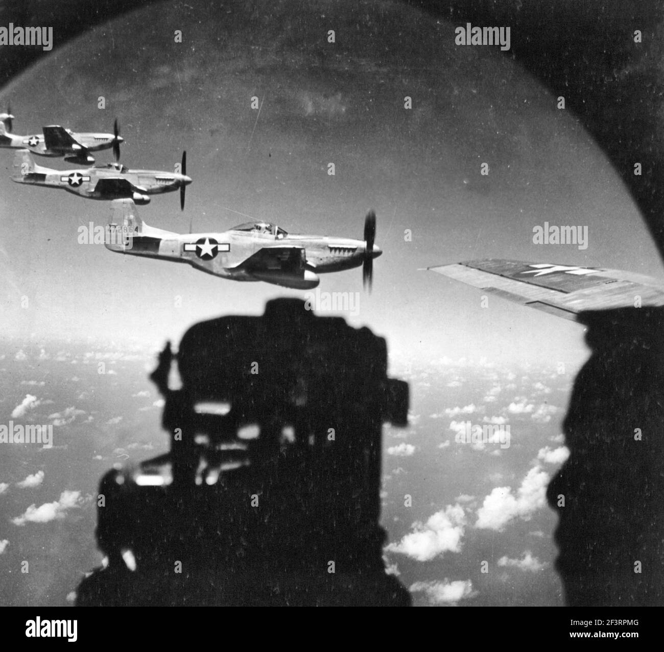 Waist Gunner Of Escort B-29 Superfortress Watches A Trio Of North American P-51 Mustangs Flying Close-In During A Fighter Sweep To Japan Stock Photo