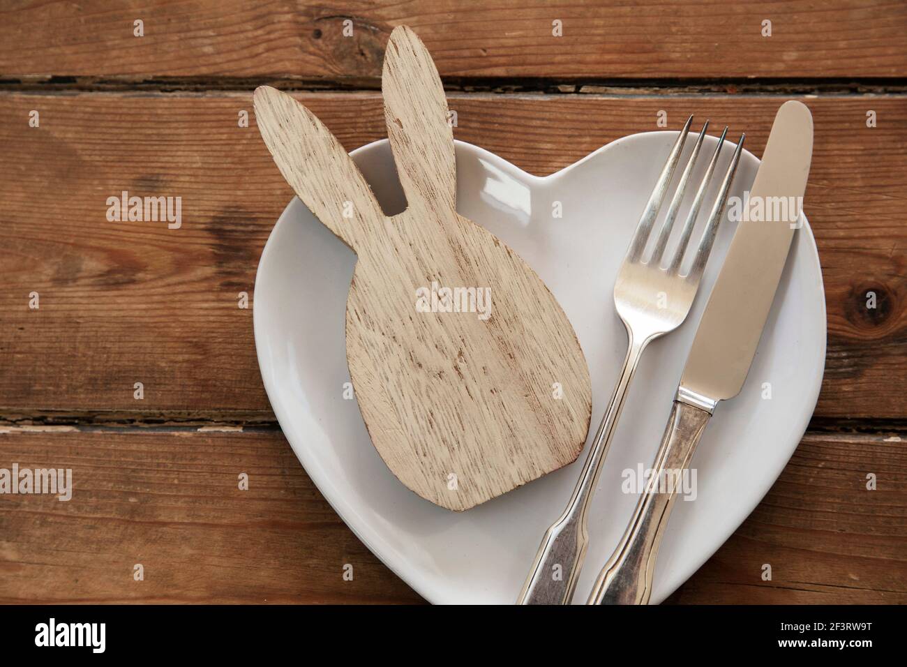 Easter table overhead view with a rabbit shape on a plate with cutlery Stock Photo