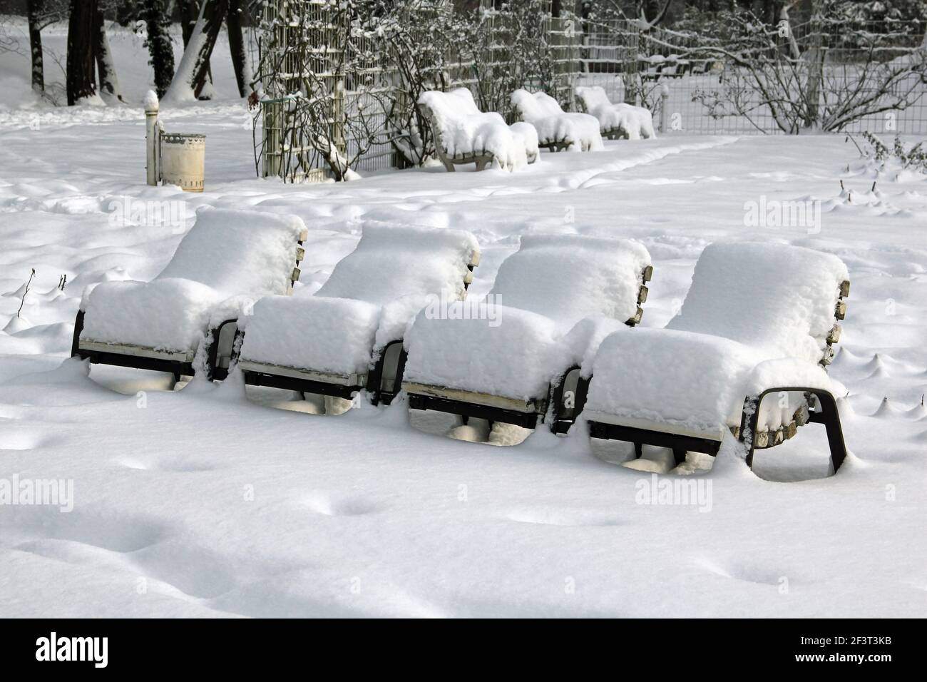 Snow-covered park-chairs in a municipal park Stock Photo