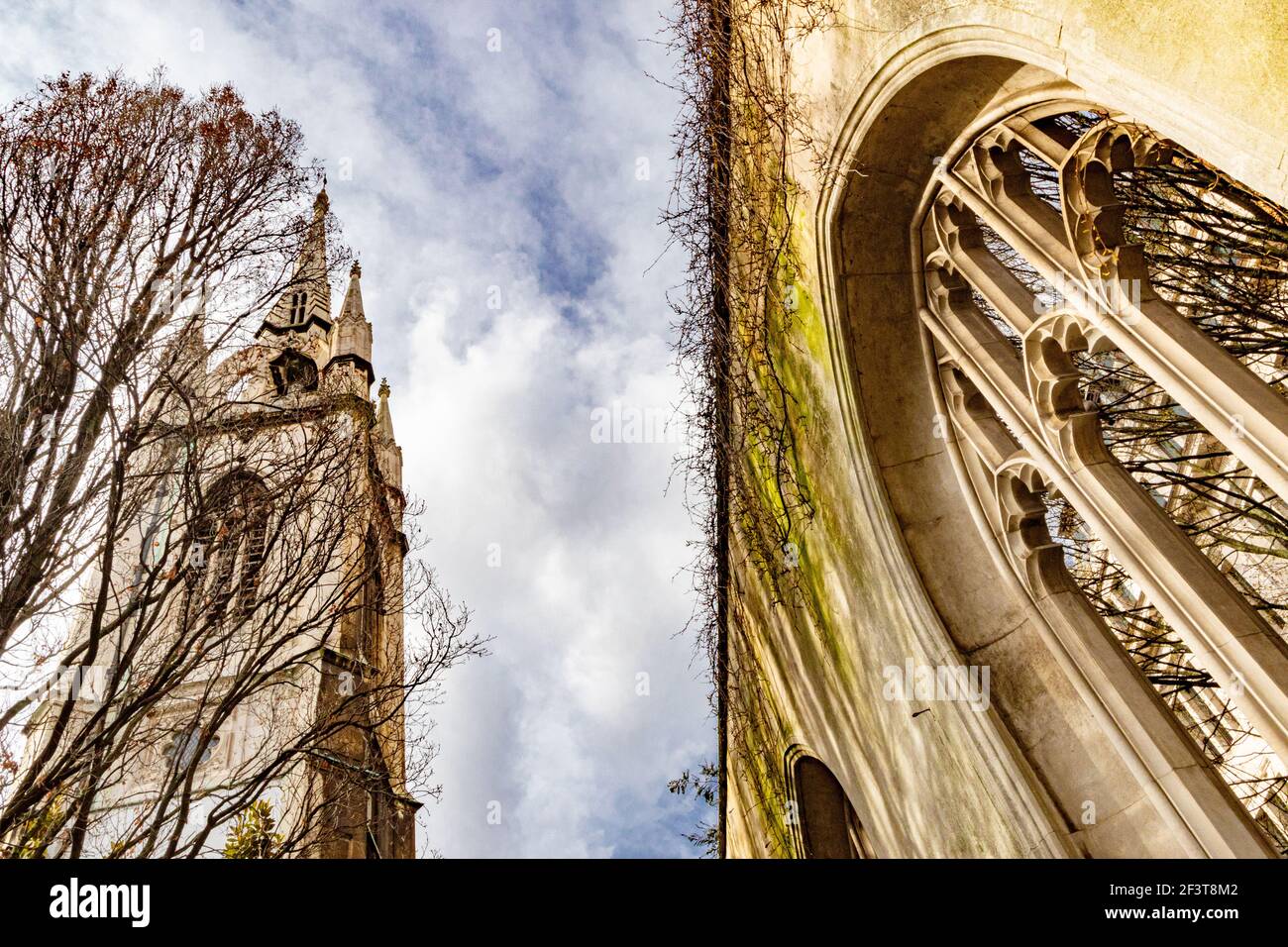 Dramatic view of the church tower and remant of gothic arched window of St Dunstan in the East, London - Stock Image