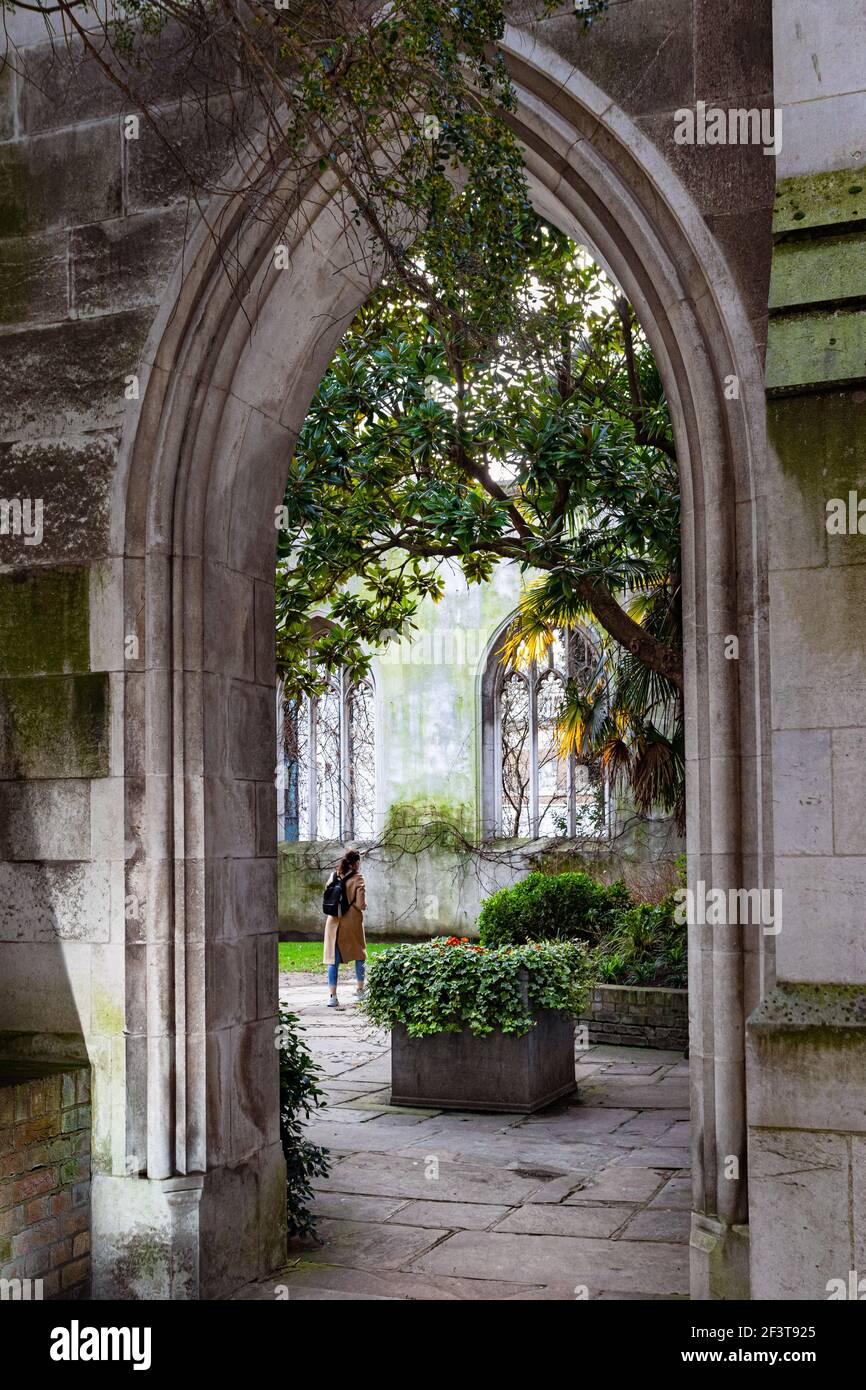 The garden of St Dunstan in the East seen through a gothic arched entrance - Stock Image