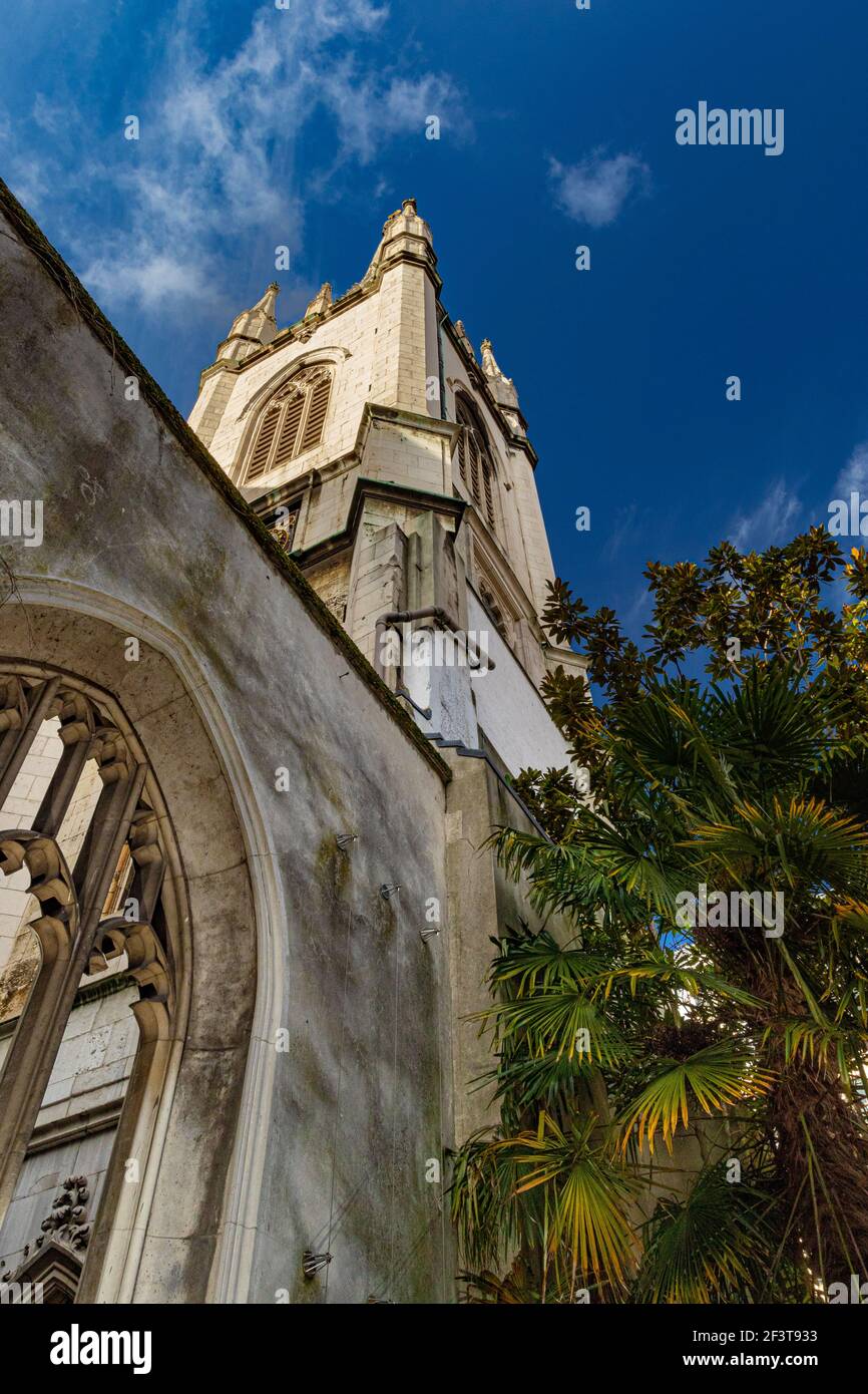 Looking up at the tower of St Dunstan in the East with Fan Palm and gothic arced window - Stock Image