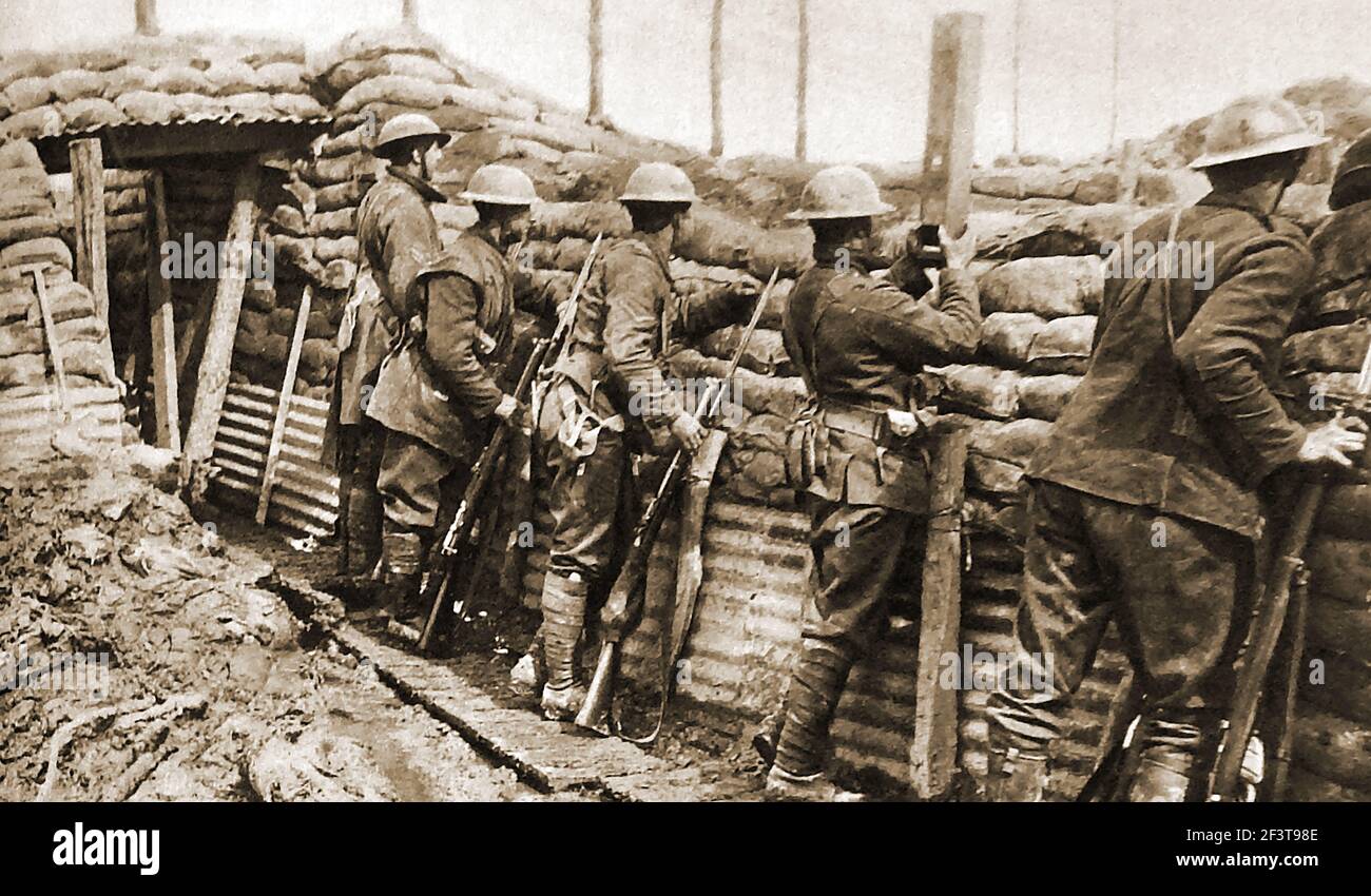 WWI - Trench warfare - Canadian troops stand ready to repel a german attack. One is using a  periscope to safely see over the trench top. Stock Photo