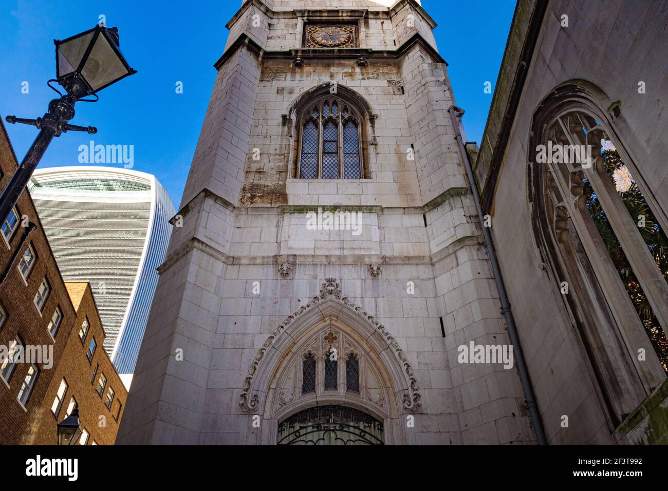 Street view looking up at the tower of St Dunstan in the East, with the tall building of 20 Fenchurch Street 'The Walkie Talkie' in the background - Stock Image
