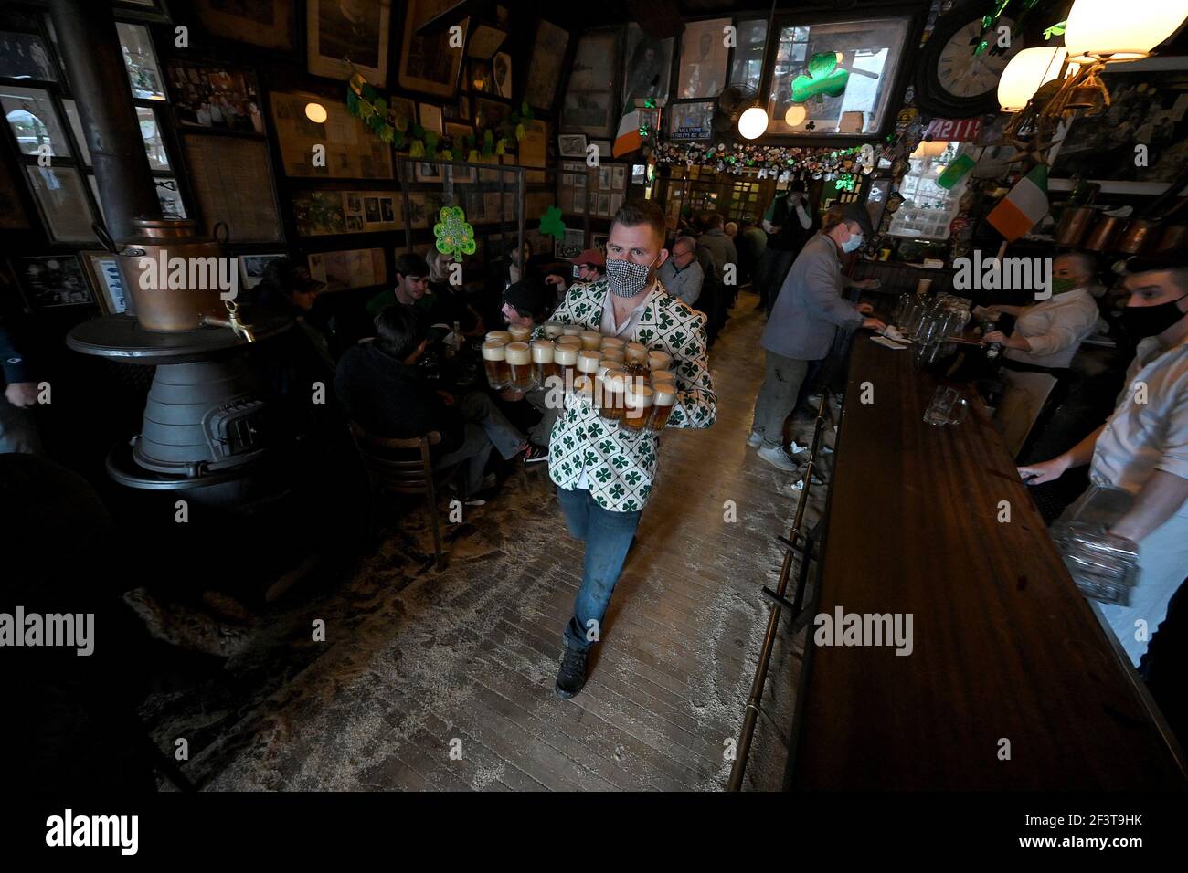 Know as the oldest Irish pub in New York City, a server carries 20 mugs of  beer to patrons celebrating St. Patrick's Day at McSorely's Old Ale House  in New York, NY,