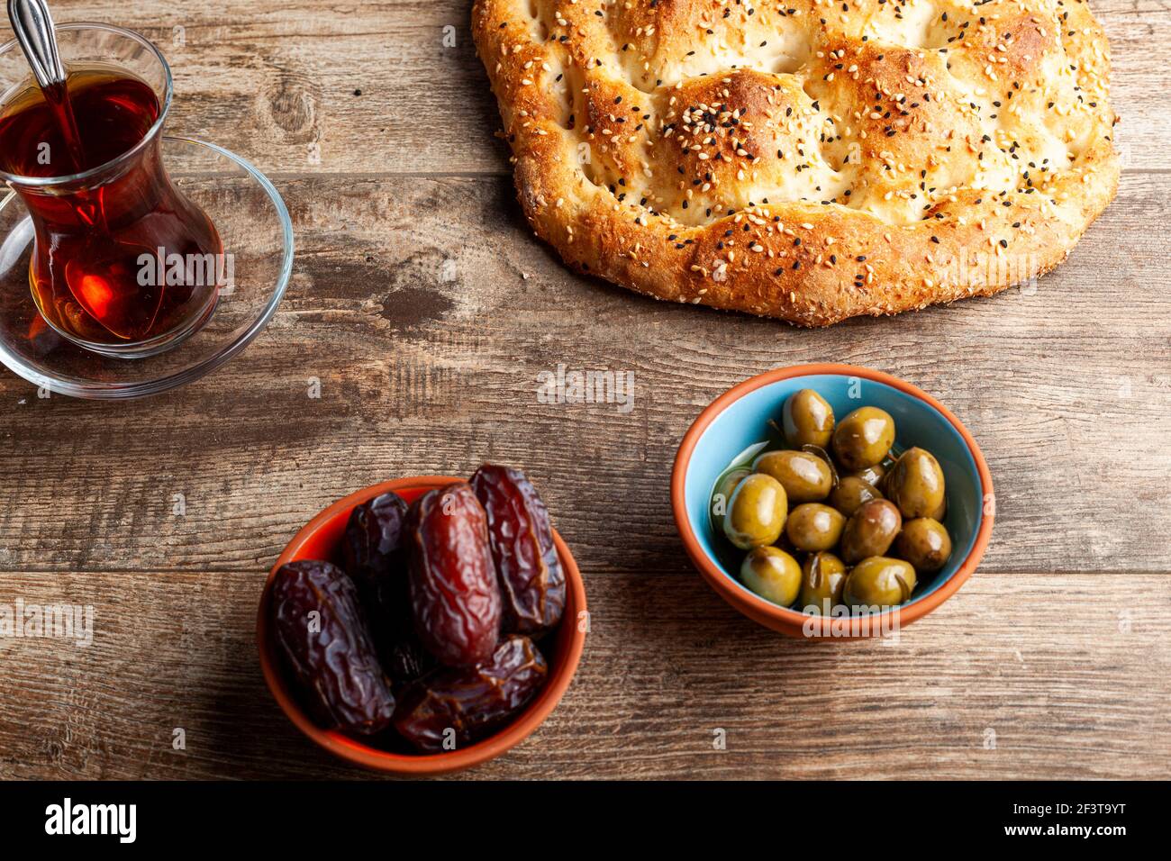 Angled view of the traditional meal for iftar and sahur in the holly month of Ramadan. Turkish tea in special glasses, ramazan pidesi,  a type of flat Stock Photo