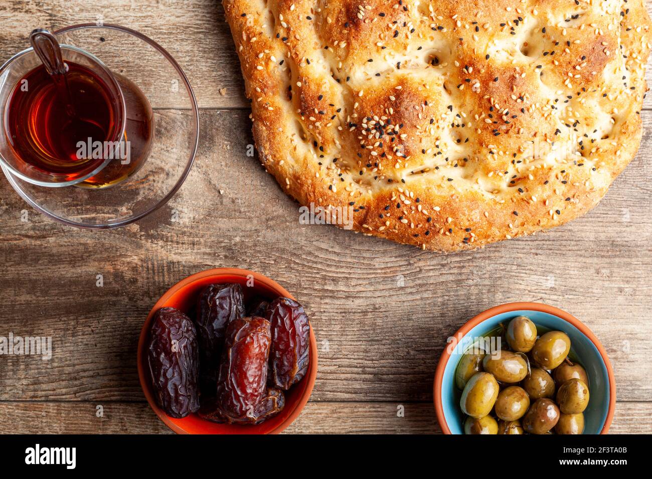 Flat lay image of a traditional meal for iftar and sahur in the holly fasting month of Ramadan. Turkish tea in special glasses, ramazan pidesi,  a typ Stock Photo