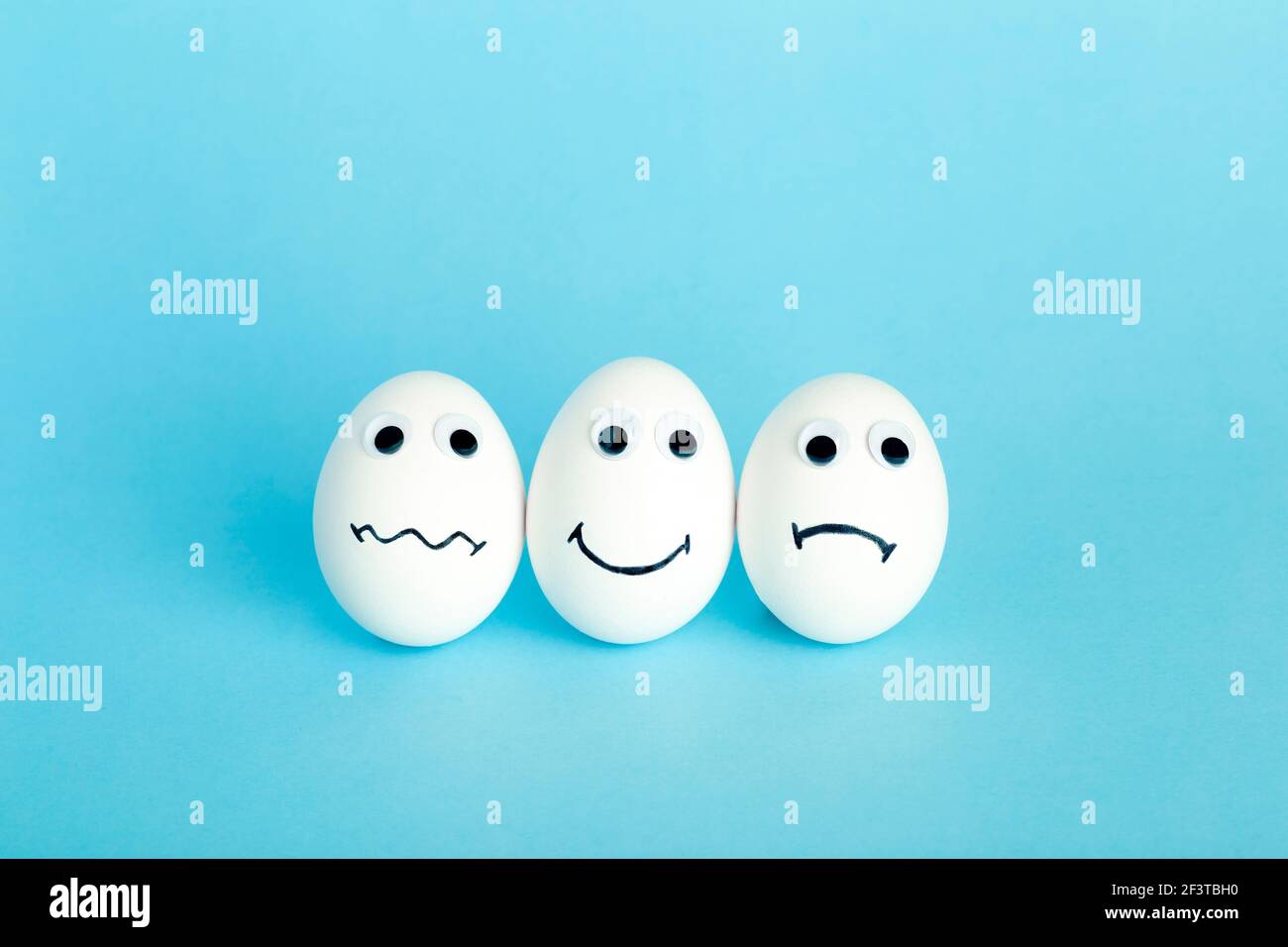 Fun creative food for kids. Eggs minimal concept. White funny eggs for breakfast on a colored background. Stock Photo