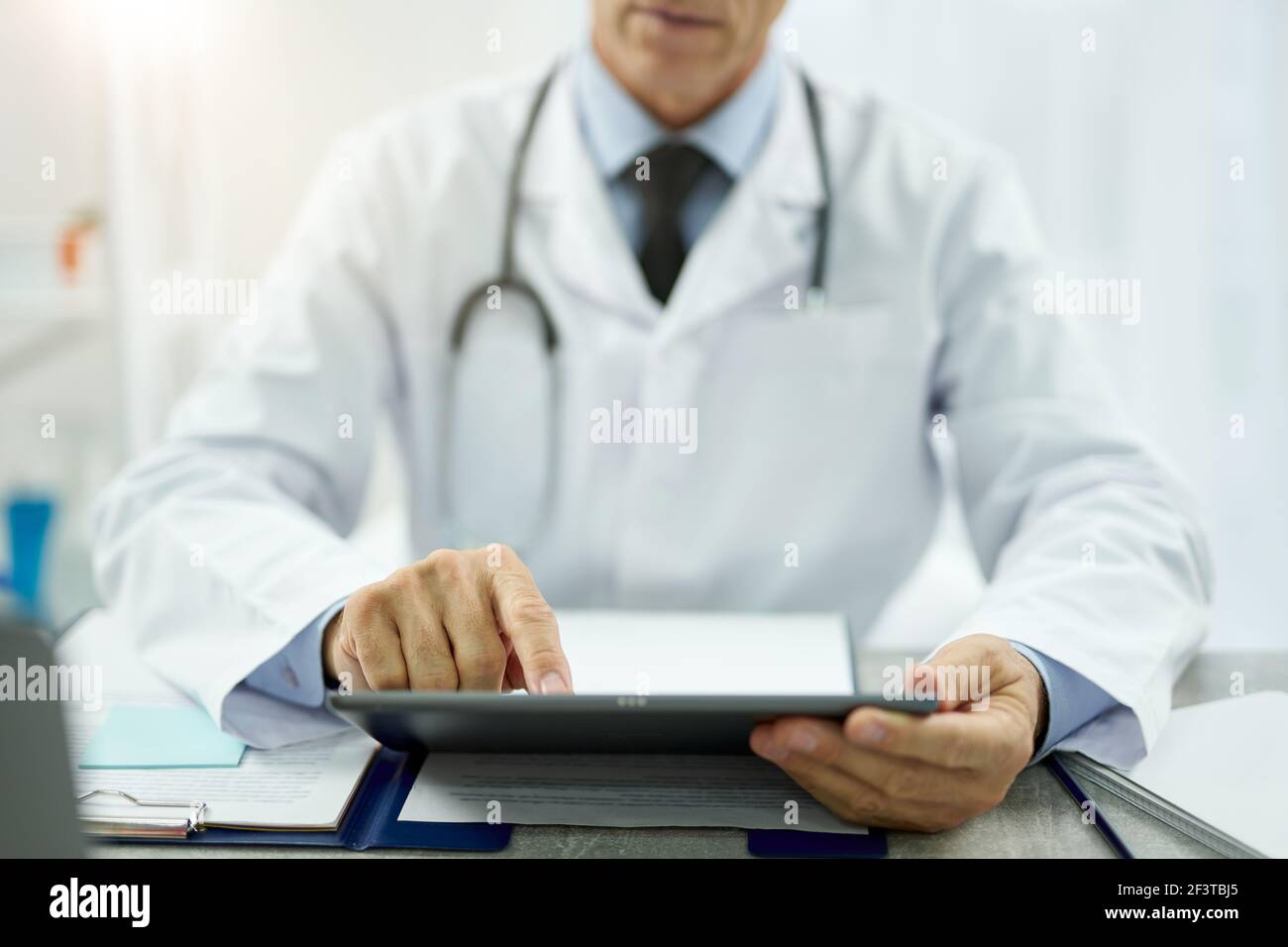 Male doctor using tablet computer at work Stock Photo - Alamy