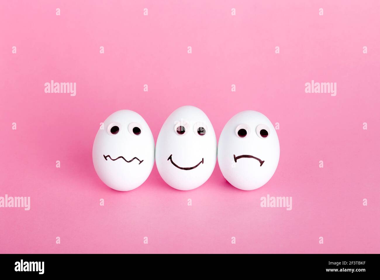 Fun creative food for kids. Eggs minimal concept. White funny eggs for breakfast on a colored background. Stock Photo