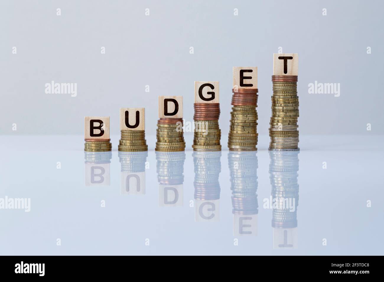 Word "BUDGET" on wooden blocks on top of ascending stacks of coins. Concept photo of increase of wealth, economy, business, finance and success. Stock Photo