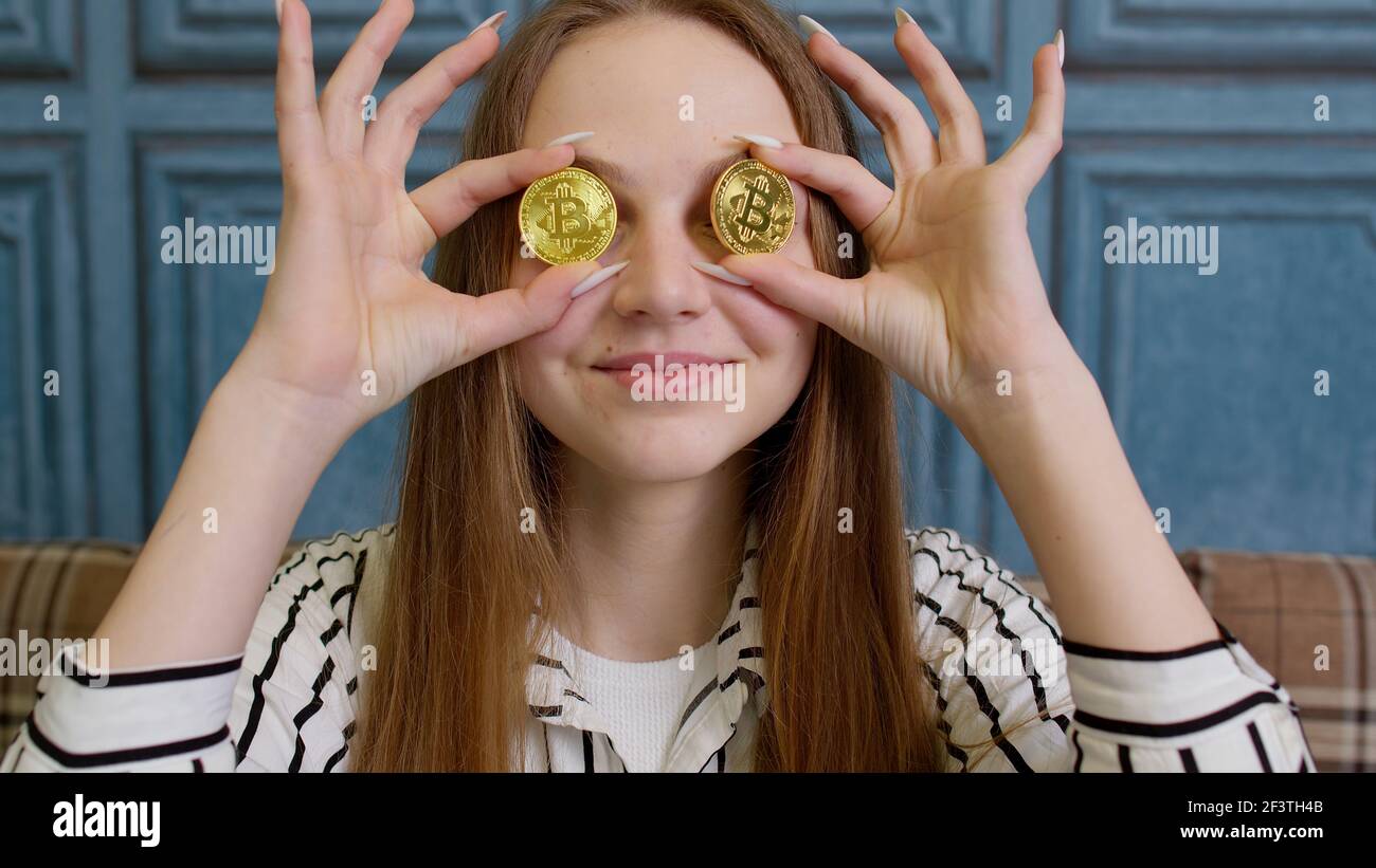 Woman freelancer holding two gold coins at home, successful developer  programmer, earning bitcoins Stock Photo - Alamy