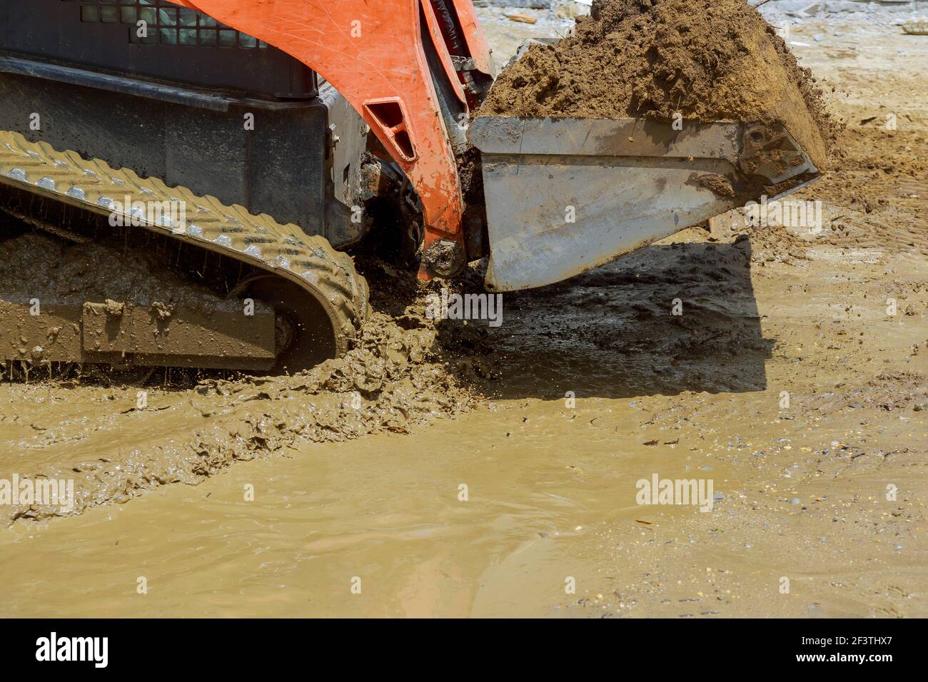 Small tractor digging land working with land Stock Photo