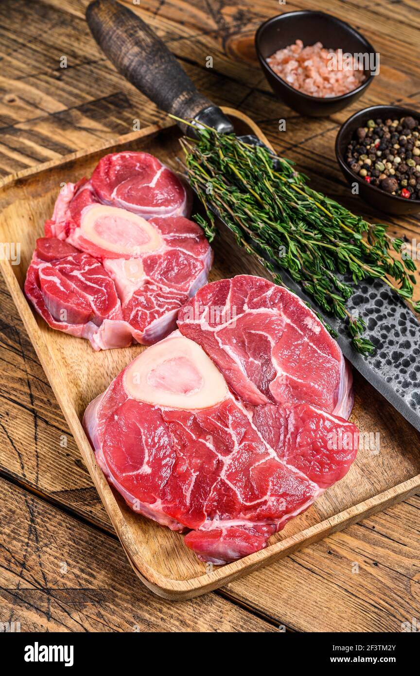 Raw veal cross cut shank meat osso buco, cooking italian ossobuco. Wooden background. Top view