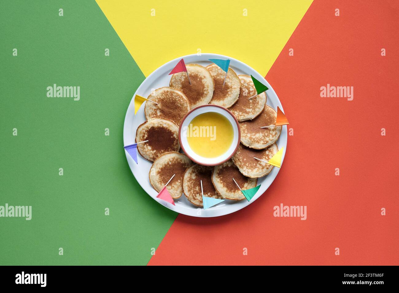Plate of small round pancakes with colorful party topper flags on split