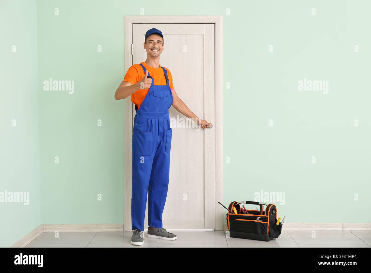 Worker showing thumb-up near door Stock Photo