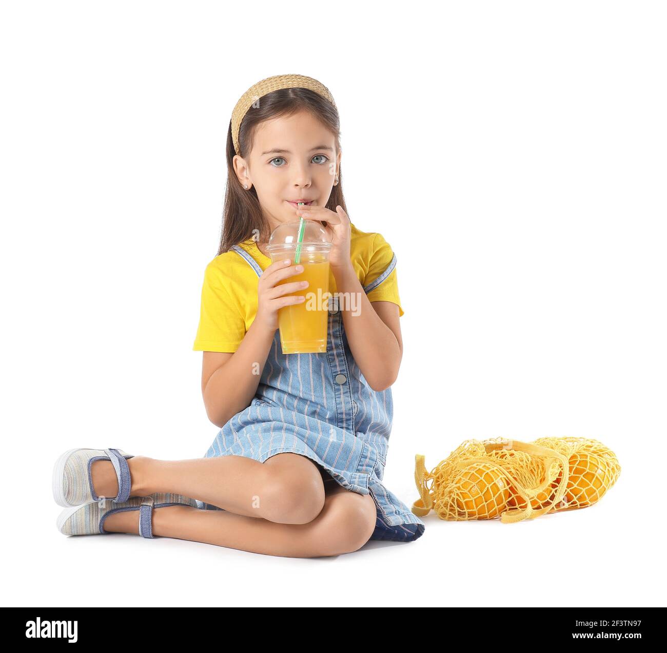 Cute little girl drinking orange juice on white background Stock Photo ...
