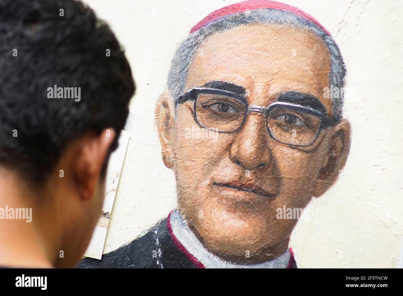 San Salvador, El Salvador. 17th Mar, 2021. CRISTIAN L'PEZ restores a mural of Saint Oscar Arnulfo Romero outside of the San Salvador cathedral a week before the 41st martyrdom anniversary of the archbishop that was murdered on March 24th, 1980, while celebrating mass.El Salvador reports 62,531 confirmed cases and 1962 deaths. Credit: Camilo Freedman/ZUMA Wire/Alamy Live News Stock Photo