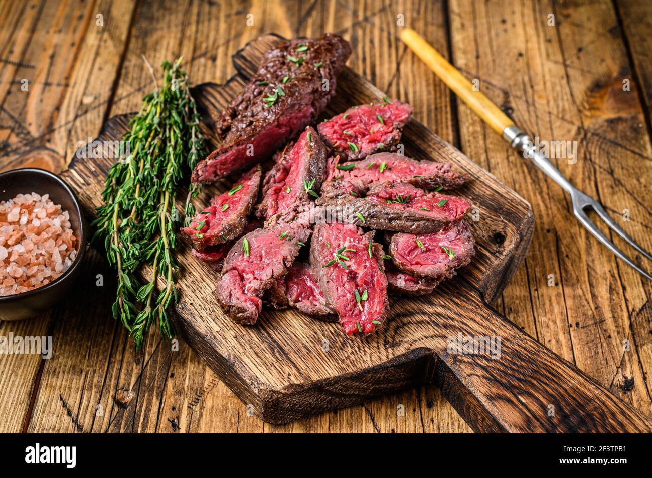Sliced grilled machete skirt meat beef steak on a wooden cutting board. wooden background. Top view Stock Photo