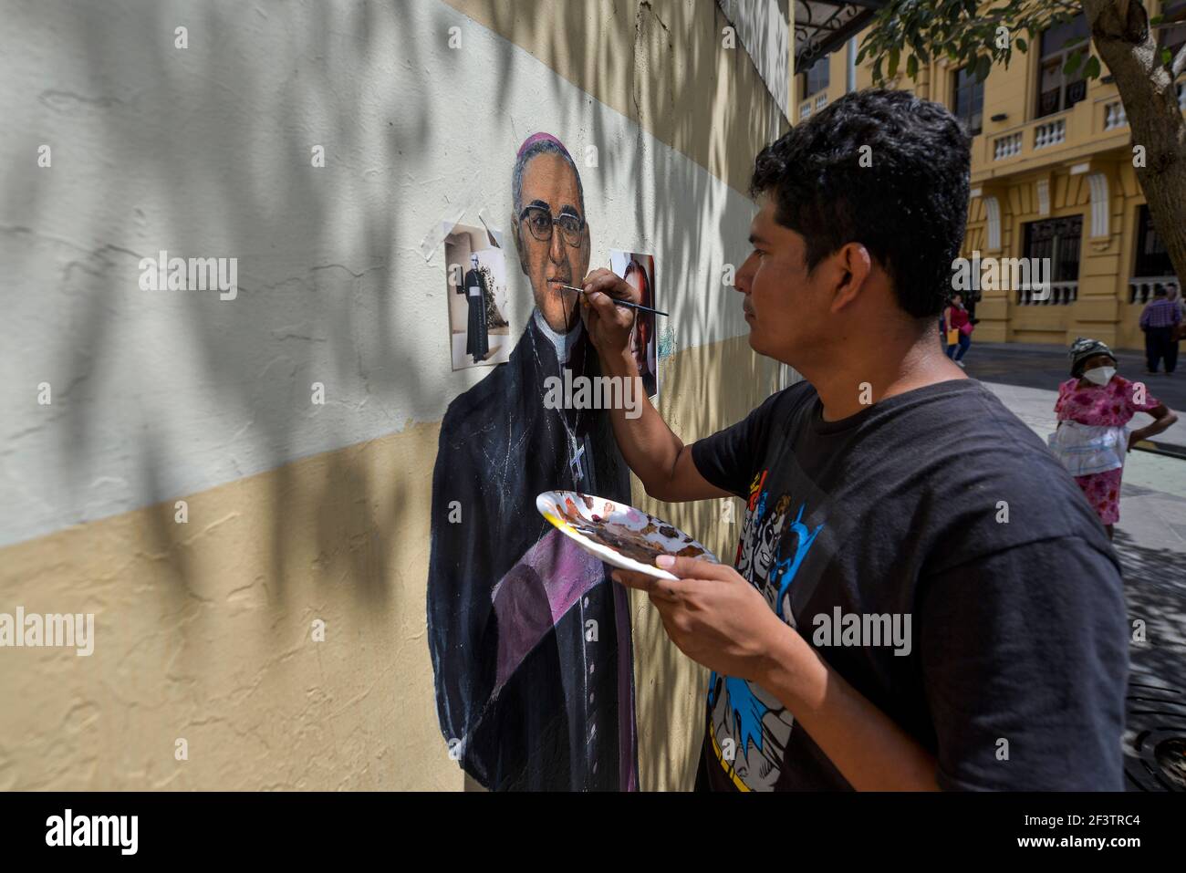San Salvador, El Salvador. 17th Mar, 2021. CRISTIAN L'PEZ restores a mural of Saint Oscar Arnulfo Romero outside of the San Salvador cathedral a week before the 41st martyrdom anniversary of the archbishop that was murdered on March 24th, 1980, while celebrating mass.El Salvador reports 62,531 COVID-19 confirmed cases and 1962 deaths. Credit: Camilo Freedman/ZUMA Wire/Alamy Live News Stock Photo