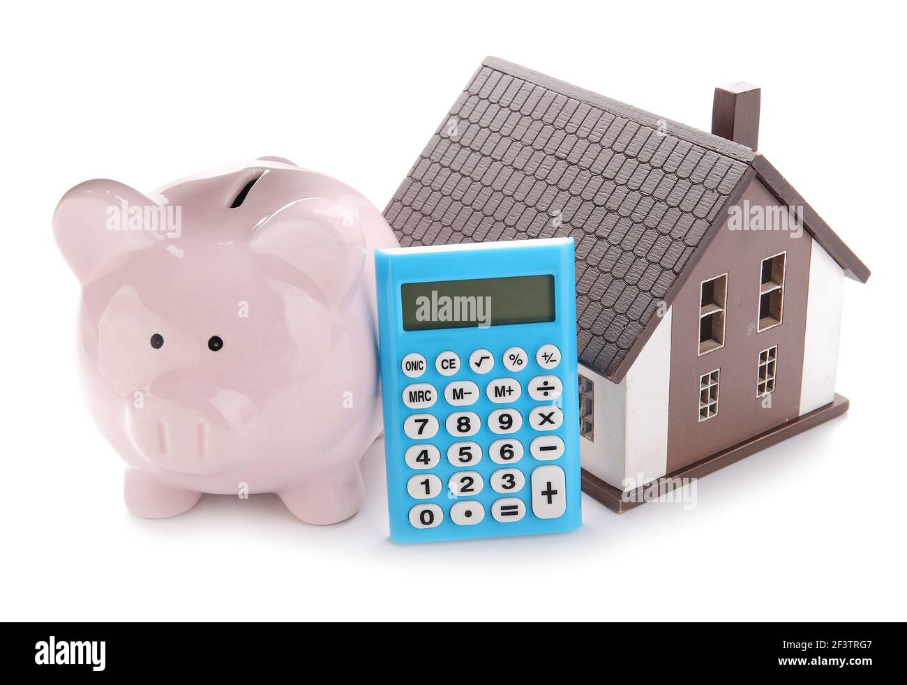 Calculator with model of house and piggy bank on white background Stock ...