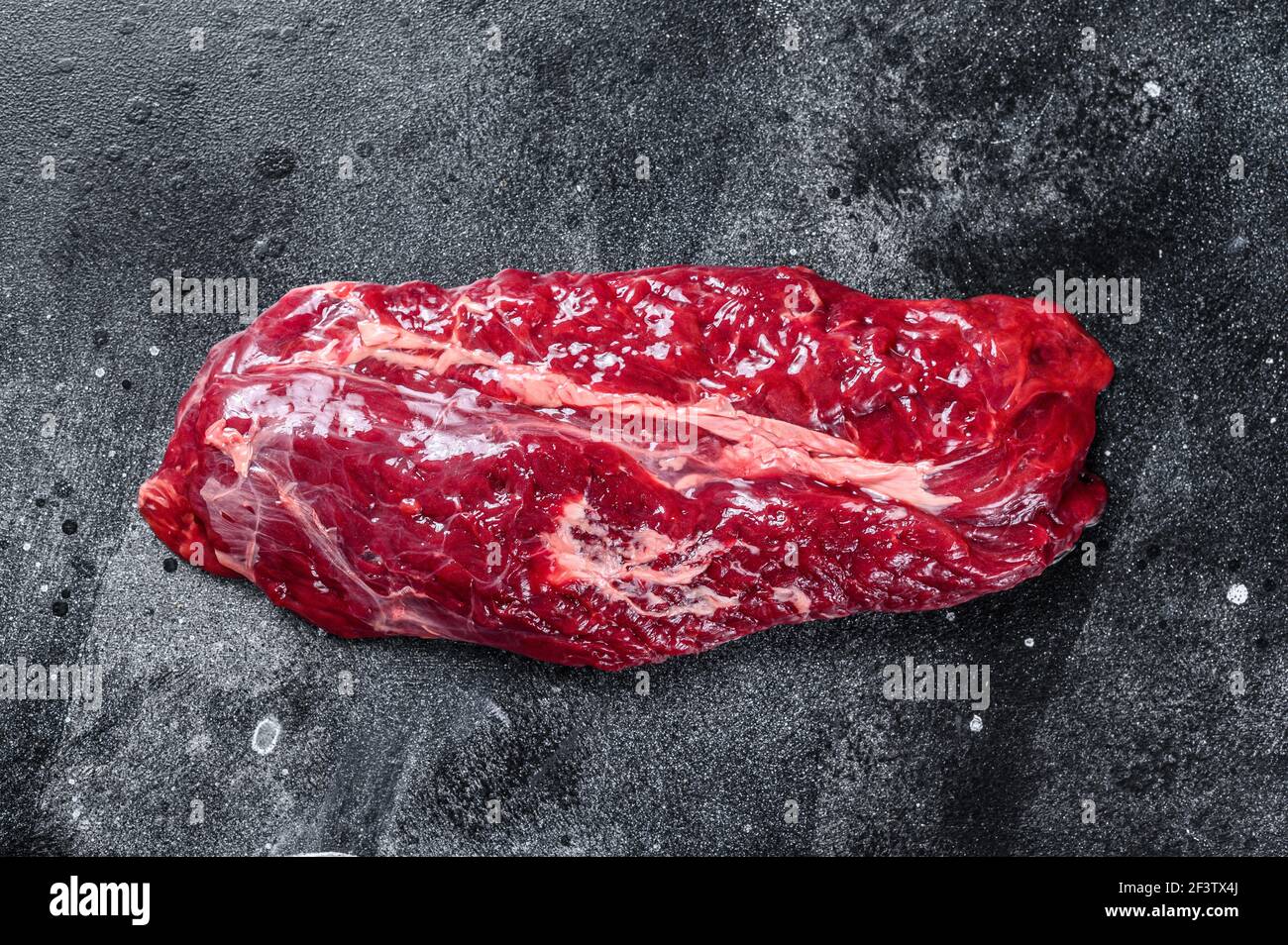 Raw Hanging Tender beef meat steak. Black background. Top view Stock Photo
