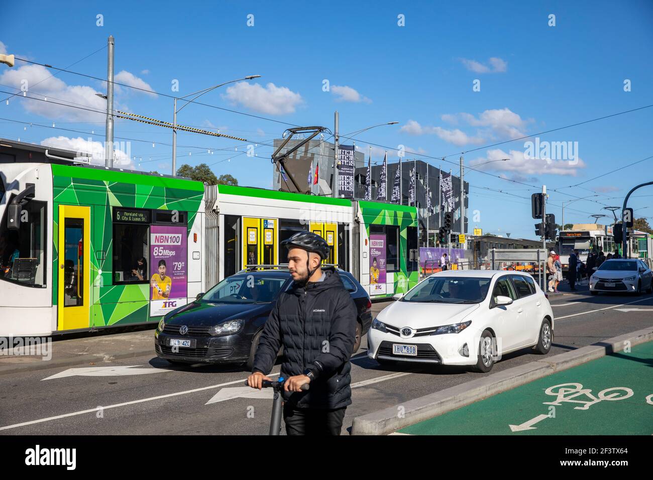Melbourne city centre, melbourne tram on princes bridge and man riding as scooter in the bike