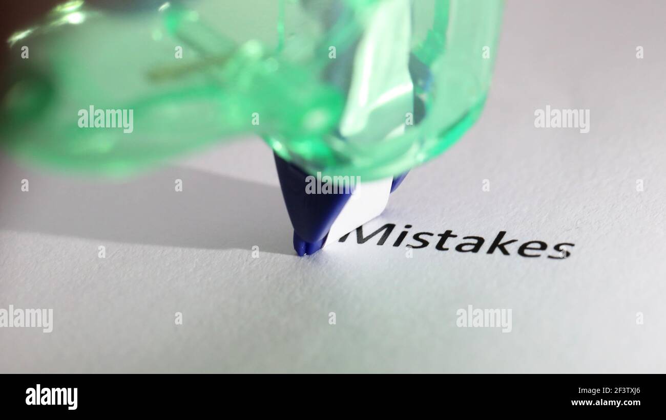 The word or text 'mistakes' about to be removed, erased, covered or deleted. Close up of correction tape removing or hiding the word. Stock Photo