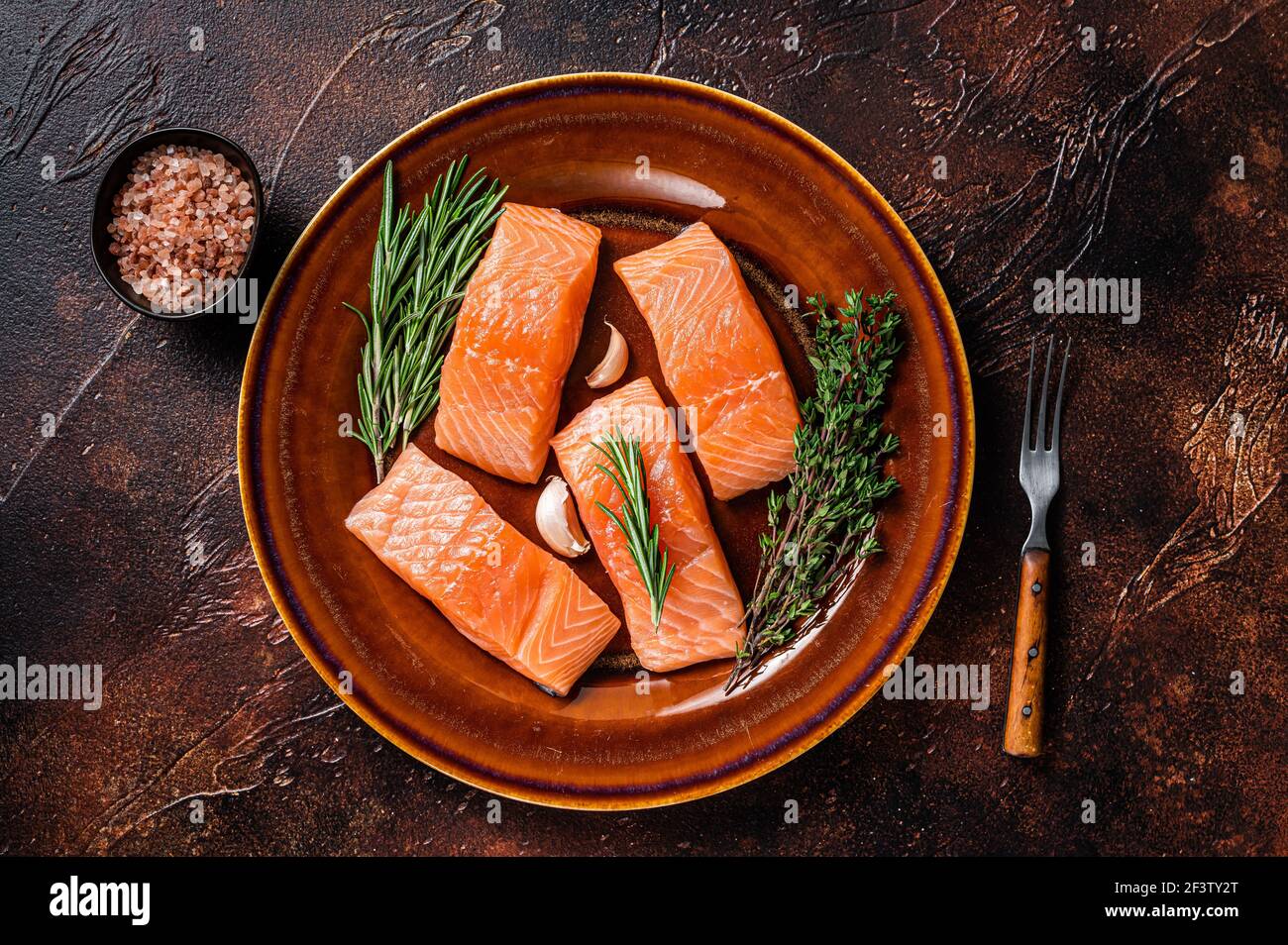 Fresh Raw salmon fish fillet steaks on rustic plate with thyme and ...
