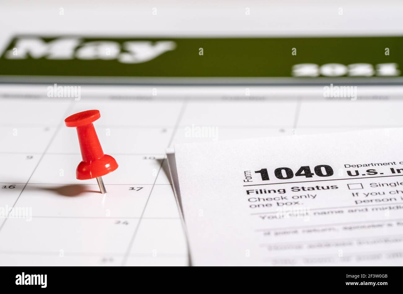 Calendar with pushpin inserted in the date for May 17 to illustrate the new tax return filing date of f17th May 2021. Stock Photo