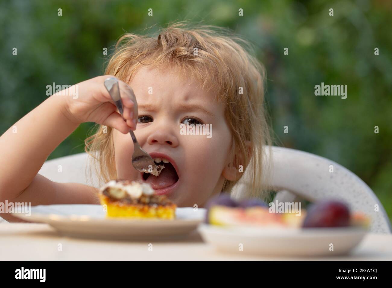 Baby eating cake. Child eat cupcake outdoors Stock Photo Alamy