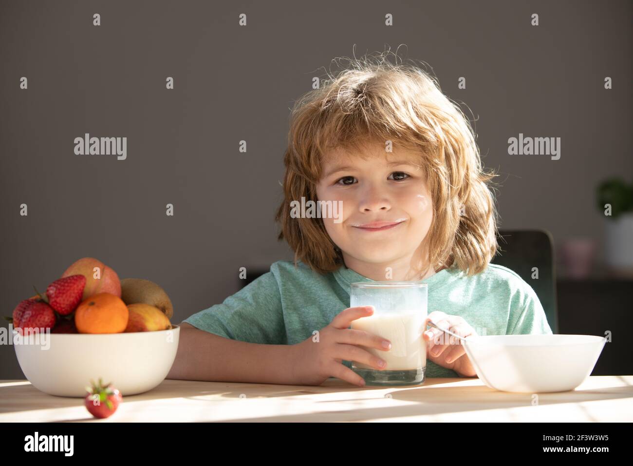 Child with glass of milk eating healthy food. Stock Photo