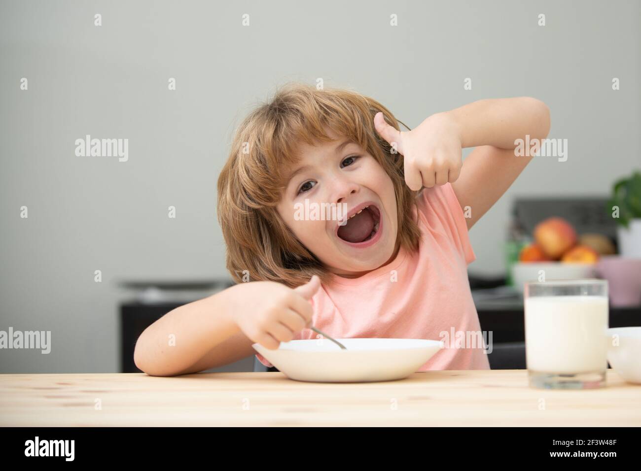 Healthy nutrition for kids. Caucasian toddler child boy eating healthy soup in the kitchen. Stock Photo