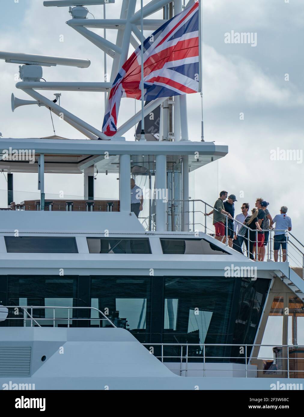 Auckland, New Zealand, 17 March, 2021 -  Owner of Ineos Team UK sailing team British billionaire Sir Jim Ratcliffe (3rd from right) prepares to view the final race of the 36th America's Cup on Auckland's Waitemata Harbour from his $100,000,000 super yacht Sherpa. Pictured with him are Ineos Team UK's founder and skipper Sir Ben Ainslie (white shirt)i with his wife Lady Ainslie (Georgie Thompson) and other guests. Following  Team New Zealand's (ETNZ) 7-3 victory over Italian challenger  Luna Rossa, Ineos Team UK are now believed to be the America's Cup Challenger of Record and will work with ET Stock Photo